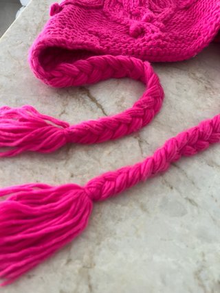 Gorro de lana rosa con pompón y trenzas