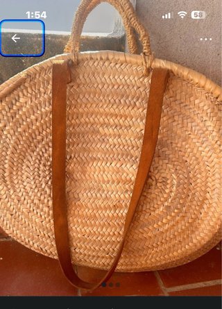 Cesta de mimbre redonda con asas de cuero