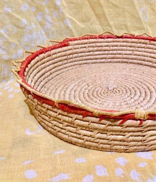Cesto de mimbre étnico con borde rojo