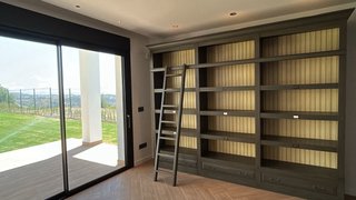 Librería beige/verde con escalera