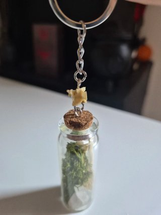 Llavero con botella de huesos y musgo