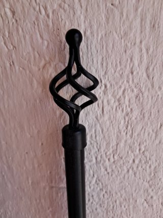 Barra de cortina negra con remate decorativo