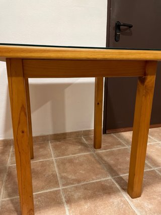 Mesa de pino macizo con tapa de cristal templado.