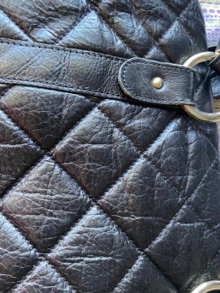 Bolso negro acolchado con detalles dorados