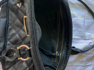 Bolso negro acolchado con detalles dorados