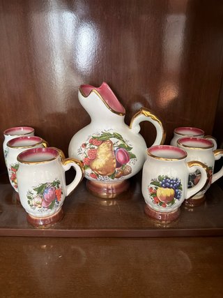 Jarra y 5 jarritas de porcelana con frutas