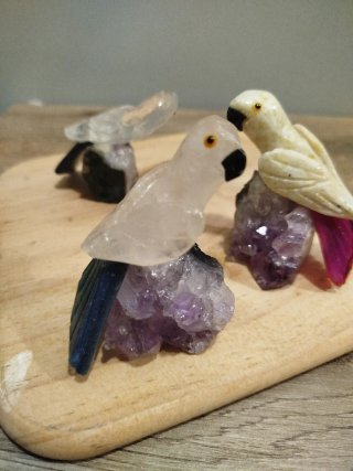 Figuras de loros en piedra y minerales