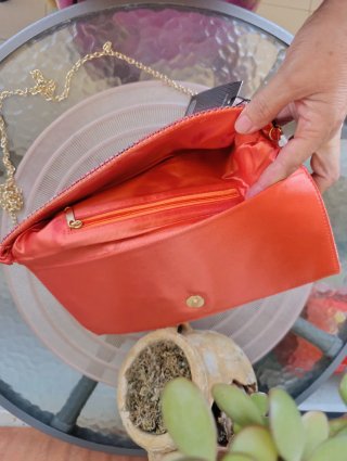 Bolso de mano naranja y dorado