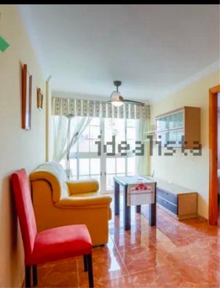 Sofá de tela amarillo y silla roja