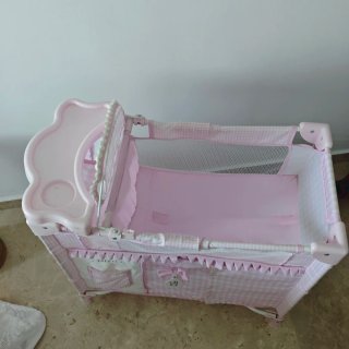 Cuna de muñeca rosa con cambiador
