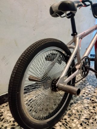 Bicicleta BMX plateada con detalles rojos