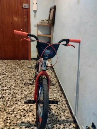 Bicicleta BMX plateada con detalles rojos