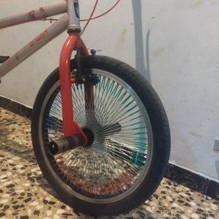Bicicleta BMX plateada con detalles rojos