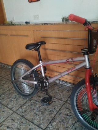 Bicicleta BMX plateada con detalles rojos