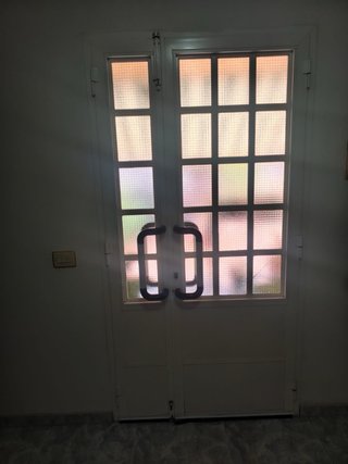 Puerta de entrada blanca con cristales