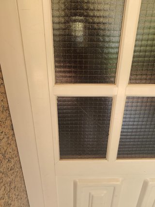 Puerta de entrada blanca con cristales