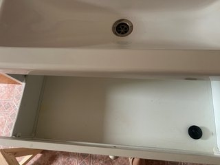 Lavabo de cerámica, mueble de madera con grifo.