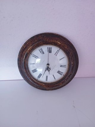 Reloj de pared redondo con números romanos