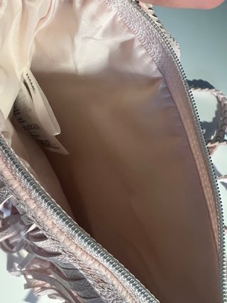 Bolso rosa con flecos y correa trenzada