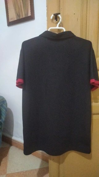 Polo negro con calavera y tibias cruzadas