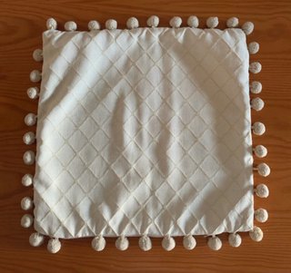 Funda cojín beige con pompones