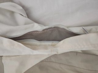 Chubasquero cortavientos beige y blanco.