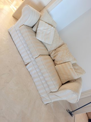 Sofá de tela beige con 2 cojines