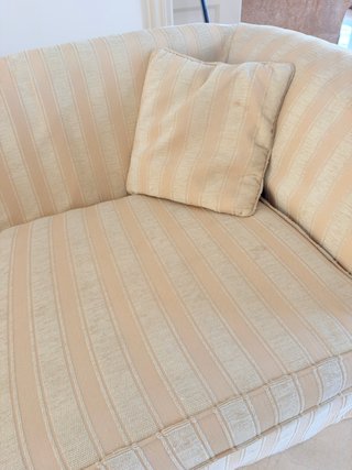 Sofá de tela beige con 2 cojines