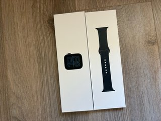Un Apple Watch SE de 40mm color negro con cargador