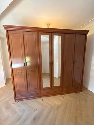 Armario de madera marrón con puertas y espejos