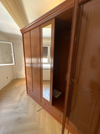 Armario de madera marrón con puertas y espejos