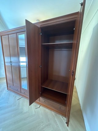 Armario de madera marrón con puertas y espejos