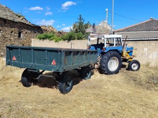 Tractor azul con remolque y pala