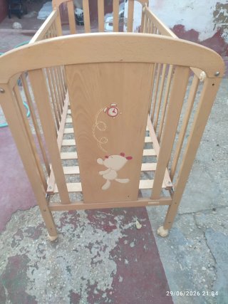 Cuna de bebé de madera color pino.