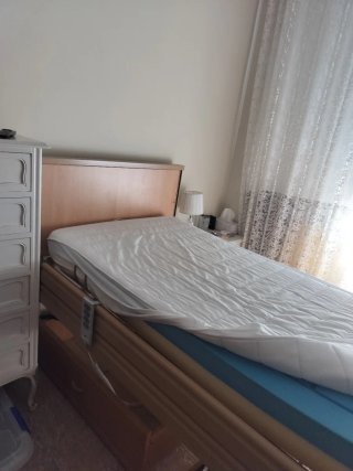 Cama articulada geriátrica con barandillas.