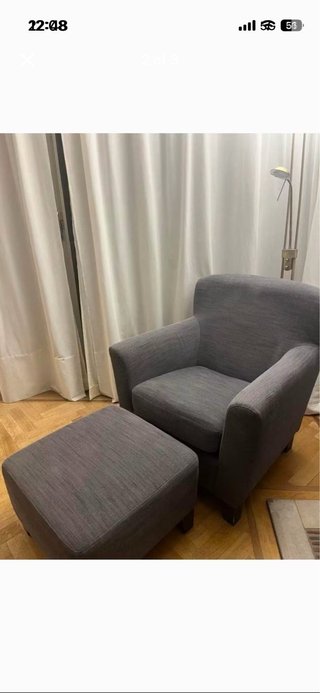 Sillón de tela gris con reposapiés