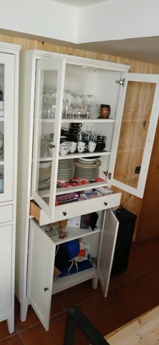 Mueble alacena blanco con puertas de cristal.