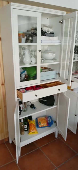 Mueble alacena blanco con puertas de cristal.