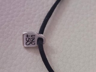 Pulsera Uno de 50 cordón negro colgante plata
