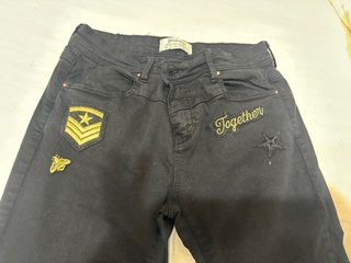 Pantalón negro con parches dorados