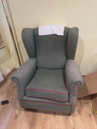 Sillón orejero verde con ribete rojo