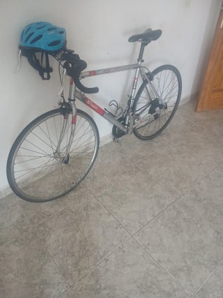 Bicicleta Btwin plateada con casco