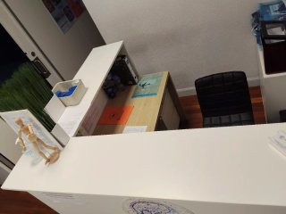 Mostrador de recepción blanco y roble en L