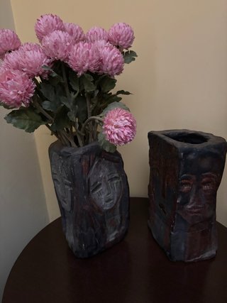 Jarrones de piedra con caras en relieve