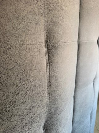 Sofá cama gris con patas plateadas