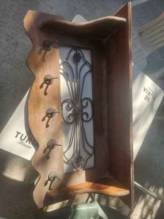 Perchero de madera con adornos metálicos
