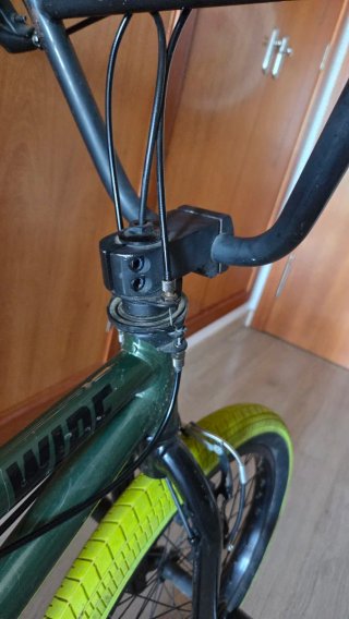 Bicicleta BMX verde con ruedas amarillas