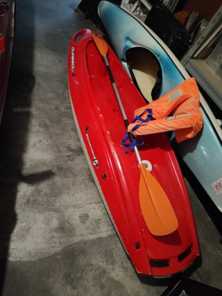 Kayak rojo con chaleco y remo