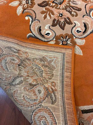 Alfombra naranja y marrón con diseño floral