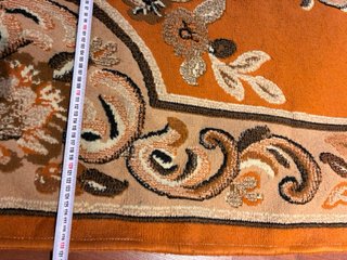 Alfombra naranja y marrón con diseño floral